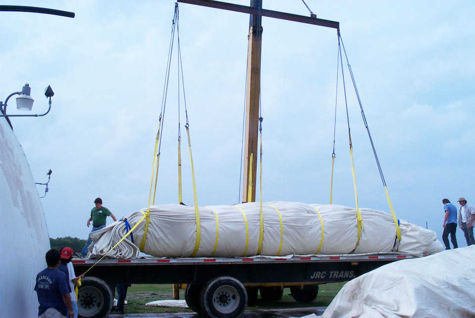 Loading a Monolithic Dome Airform — Don Garrison, Airform Division Manager, and workers use a crane to load the 265-foot half-sphere Airform created for Hovensa, a coke storage facility in St. Croix U.S. Virgin Islands.